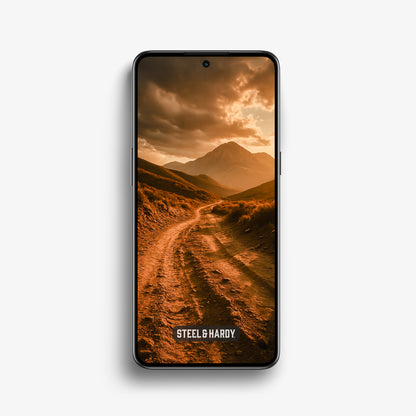 Steel & Hardy mobile wallpaper showing a dusty ridge trail at golden hour with dramatic clouds over a distant mountain